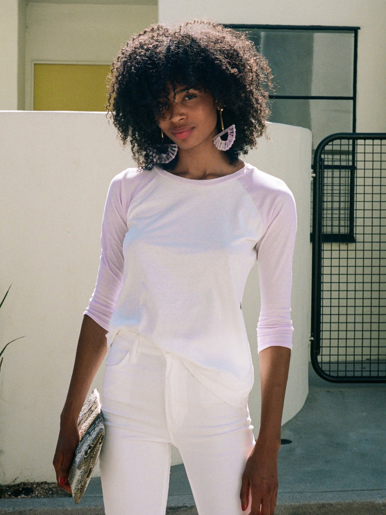 Dark haired woman in slim fit raglan t-shirt in lilac and white.