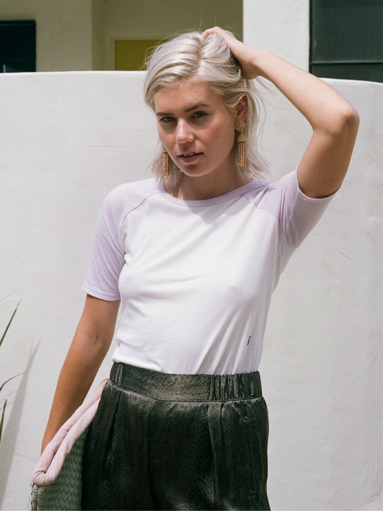 Blonde woman in short sleeved slim fit raglan shirt in lilac and white.